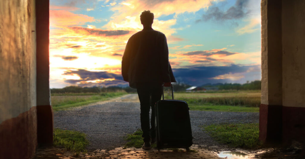 Man walking with suitcase into paradise