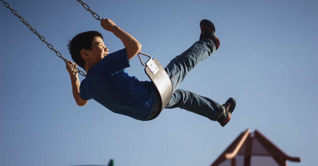Boy playing on swing